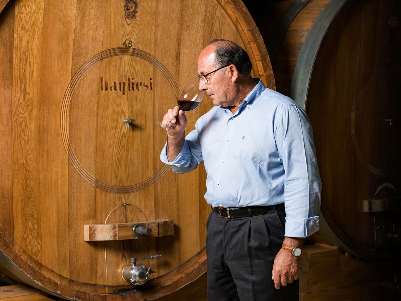 Il vignaiolo Bagliesi assaggia il vino davanti alle grandi botti di rovere