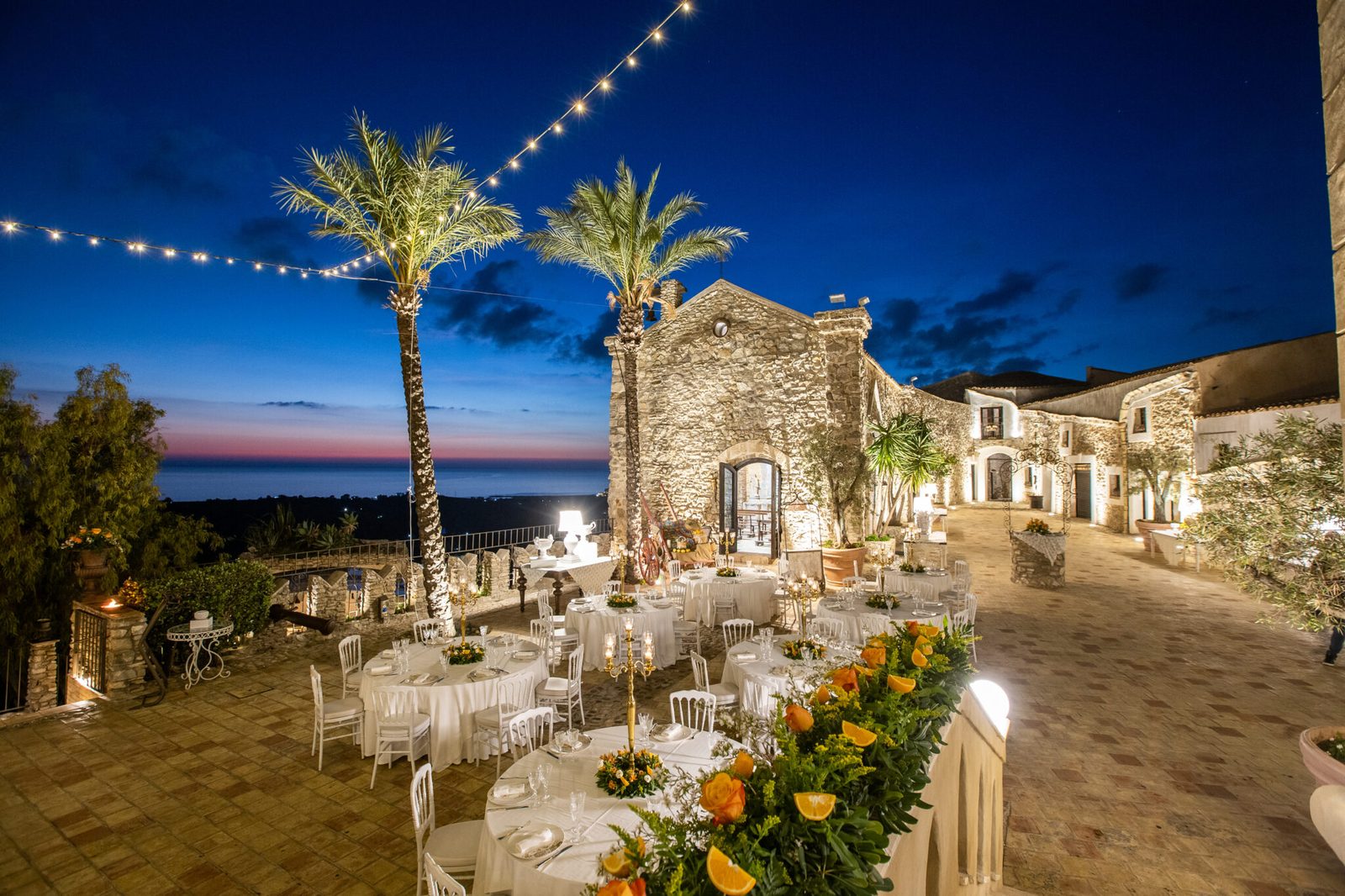 La terrazza del Castello Chiaramonte con la cappella in pietra e il mare al tramonto
