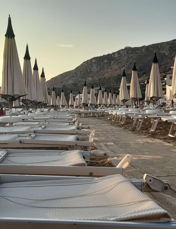 Lettini e ombrelloni del lido di Poliscia all'imbrunire